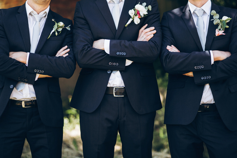 Stylish Groom in Suit Posing with Groomsmen in Garden on Wedding